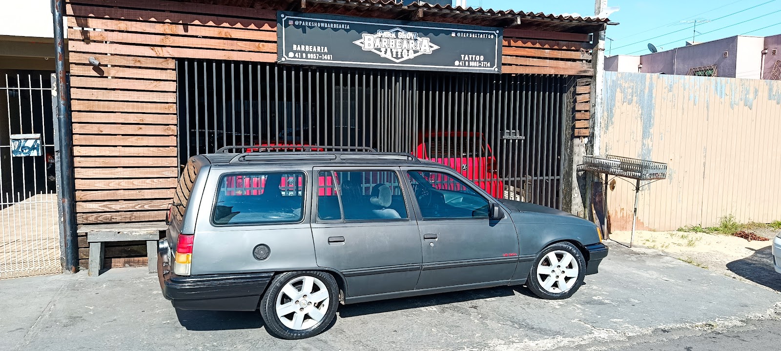 Fachada da Park Show, com placas de barbearia e de tatuagem lado a lado, no Capão Raso