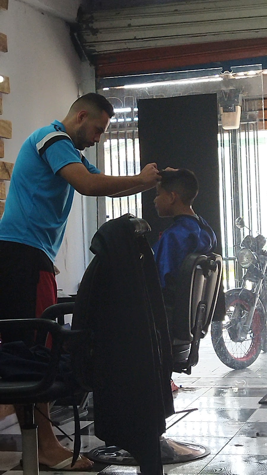 Barbeiro cortando o cabelo de um cliente dentro da Park Show